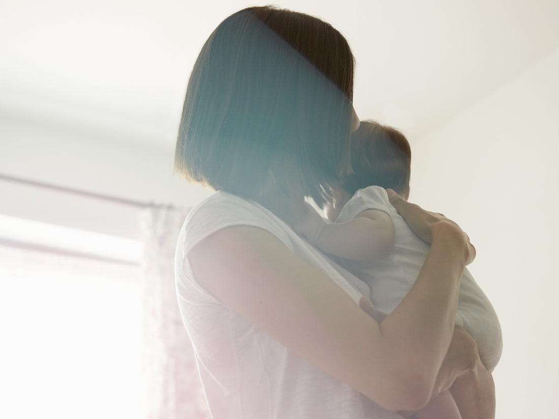 Woman holding a baby indoors