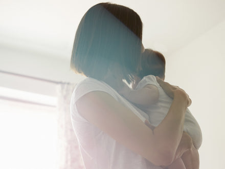 Woman holding a baby indoors
